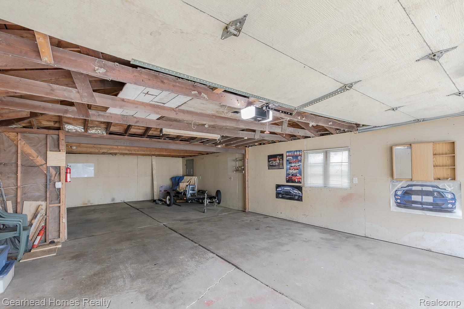 3356 Harding Street Dearborn, MI 48124 - Photo 44 of 48 Spacious garage with concrete flooring, exposed wood beam ceiling, and a wall-mounted window