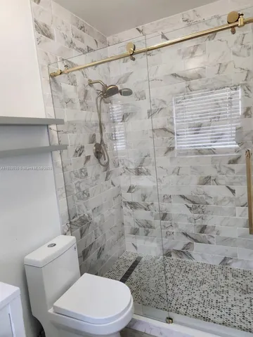 a white toilet and shower in a bathroom