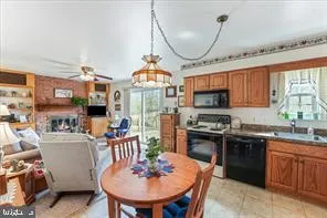 a kitchen with stainless steel appliances granite countertop a stove a sink dishwasher a dining table and chairs with wooden floor