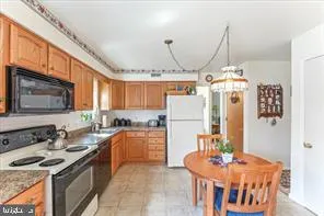 a kitchen with stainless steel appliances granite countertop a sink a stove and a refrigerator