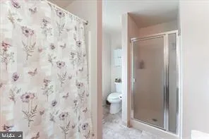 a bathroom with a granite countertop shower and a toilet