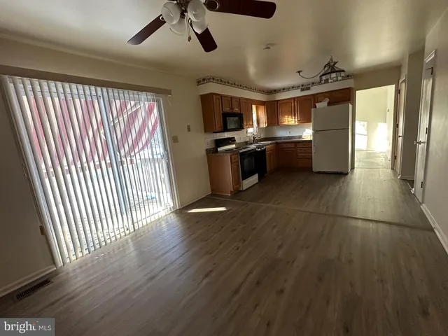 a view of a kitchen with a sink a counter top space stainless steel appliances