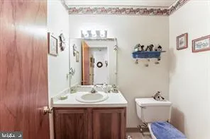 a bathroom with a sink mirror and a toilet