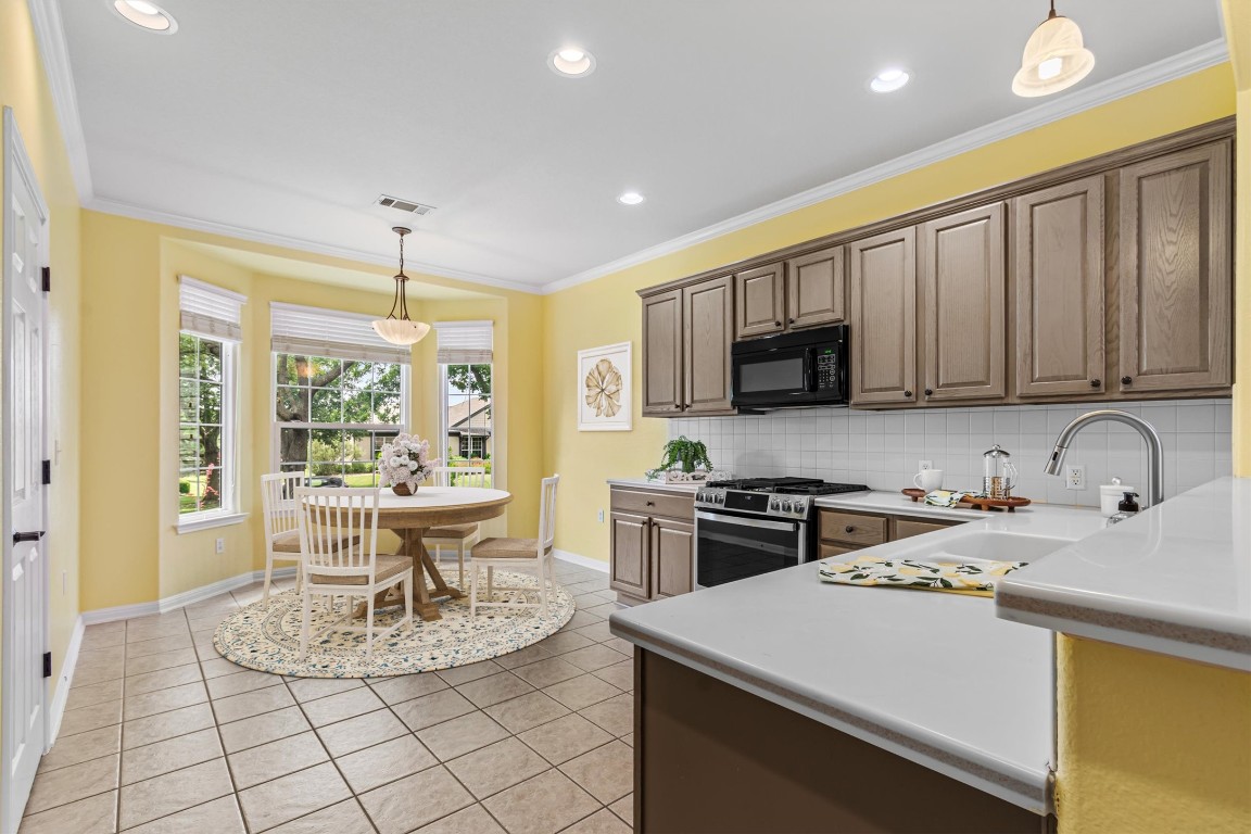 409 Rio Grande Loop Georgetown, TX 78633 - Photo 6 of 38 a kitchen with a stove a sink a microwave and wooden cabinets