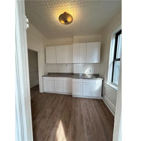 a kitchen with a refrigerator and white cabinets