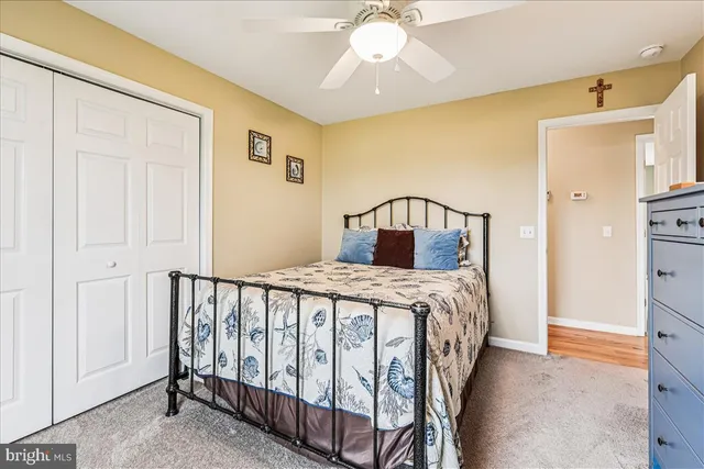 a bedroom with a bed a chandelier and dresser