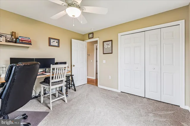 a view of a workspace with furniture and a window