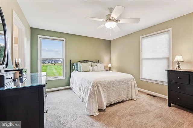 a spacious bedroom with a bed and a flat screen tv