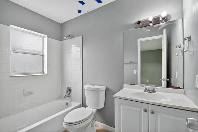 a bathroom with a granite countertop sink toilet a mirror and shower