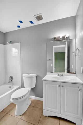a bathroom with a granite countertop toilet a sink and a mirror