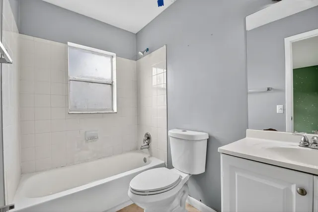 a bathroom with a granite countertop toilet a sink and a bathtub