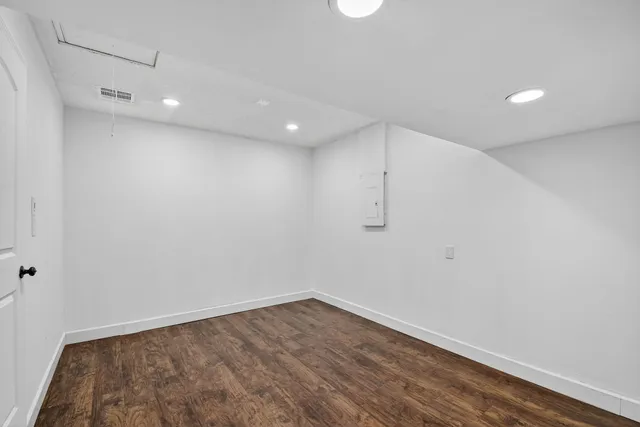 a view of empty room with wooden floor