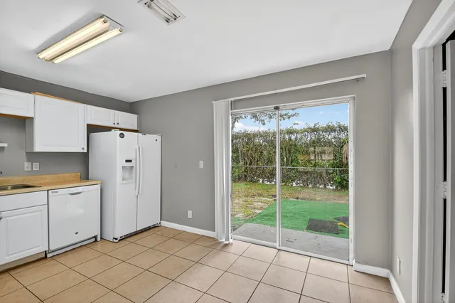 a view of a kitchen with white cabinets and a window