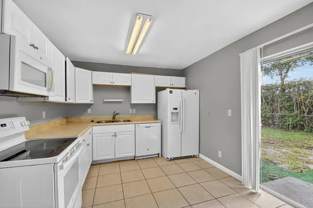 a kitchen with white cabinets and white appliances