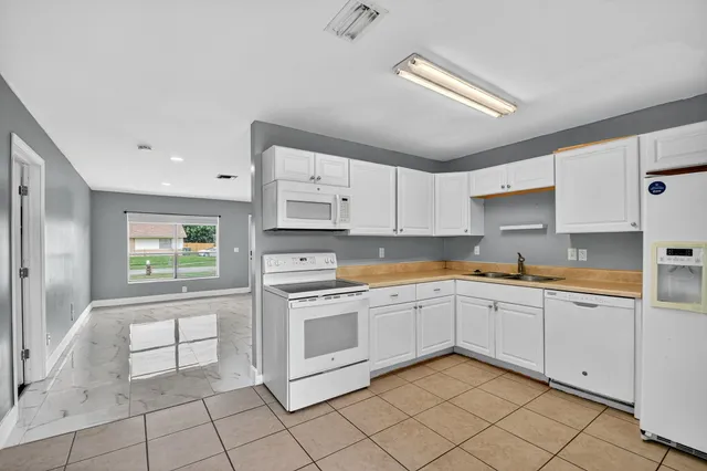 a kitchen with white cabinets appliances and a sink