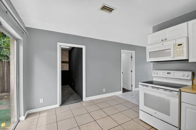 a kitchen with white cabinets and appliances