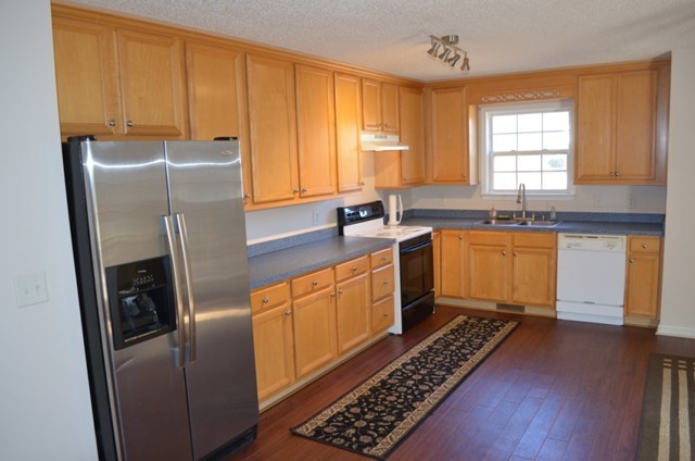 199 Orchard Ridge Drive Forsyth, GA 31029 - Photo 6 of 21 a kitchen with stainless steel appliances granite countertop a refrigerator a sink dishwasher a stove and white countertops with wooden floor