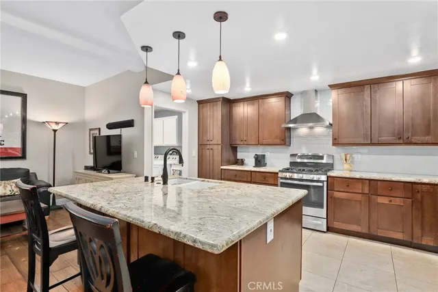 a kitchen with stainless steel appliances granite countertop a kitchen island a stove and a sink