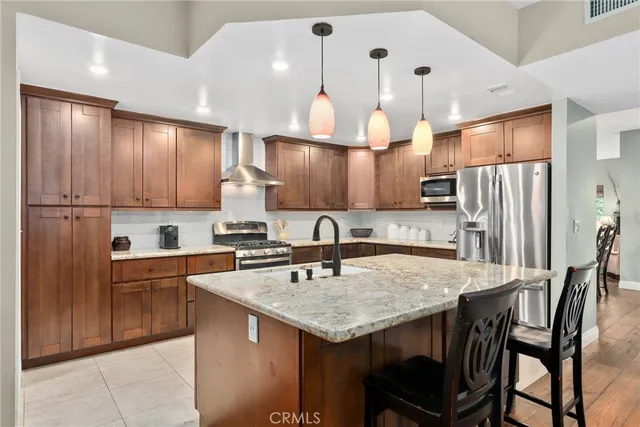 a kitchen with granite countertop a table chairs refrigerator and microwave