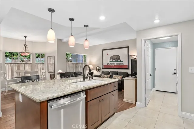 a kitchen with kitchen island granite countertop a sink and a stove