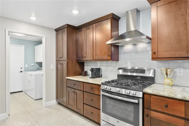 a kitchen with stainless steel appliances granite countertop a stove a sink and a refrigerator