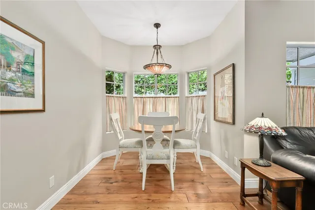 a dining room with furniture a chandelier and wooden floor
