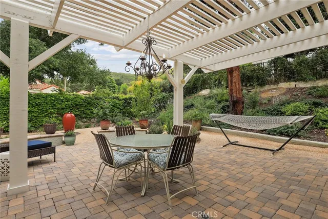a roof deck with table and chairs and potted plants