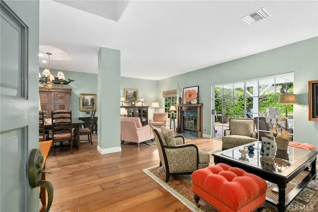 a living room with furniture a rug potted plant and a large window