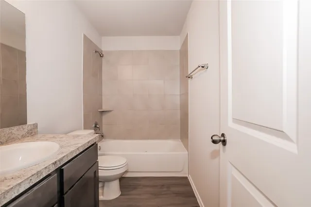 a bathroom with a granite countertop sink a toilet and shower