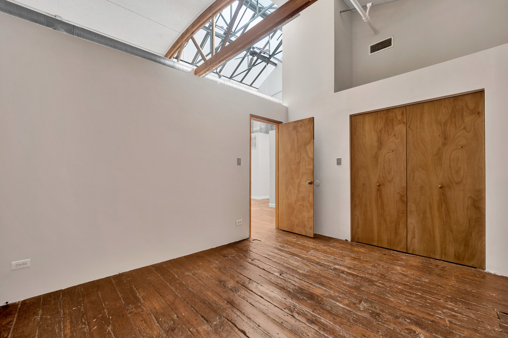 1617 South Michigan Avenue, Unit 202 Chicago, IL 60616 - Photo 9 of 14 a view of an empty room with wooden floor and a window