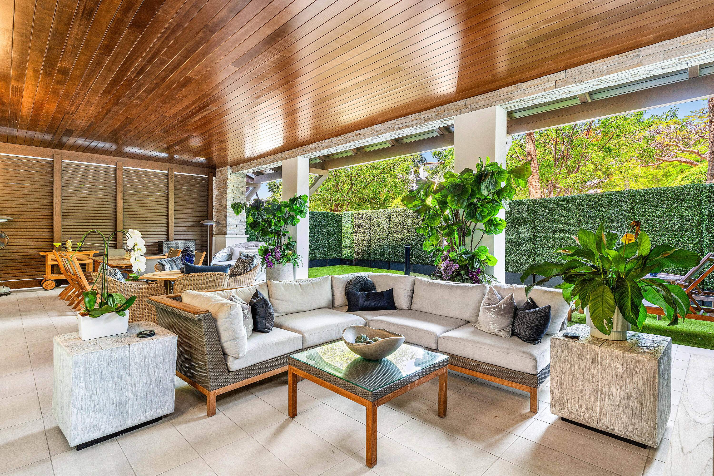 a living room with patio furniture and a potted plants