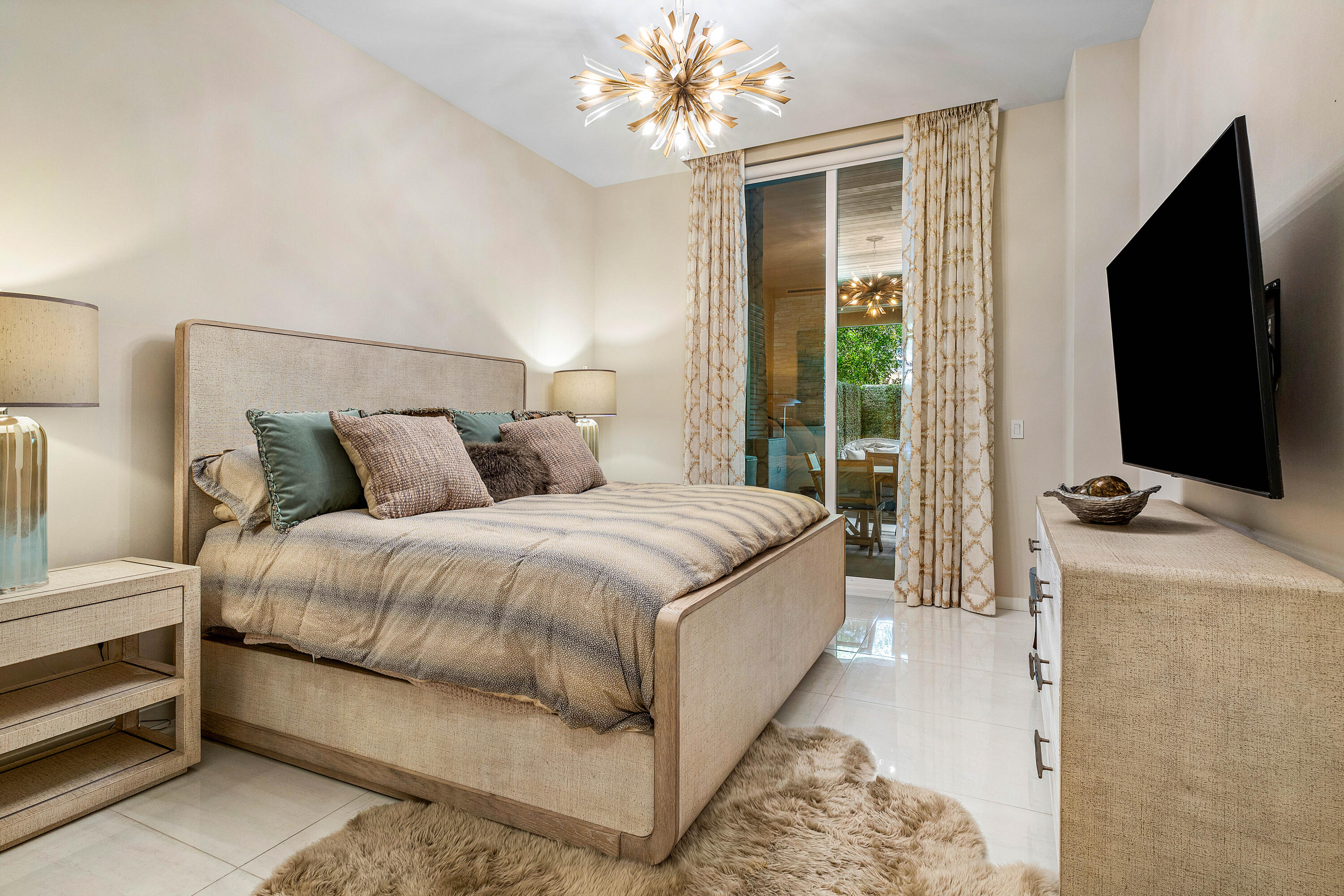 200 Southeast Mizner Boulevard, Unit 104 Boca Raton, FL 33432 - Photo 19 of 82 a bedroom with a bed and a flat tv screen on dresser