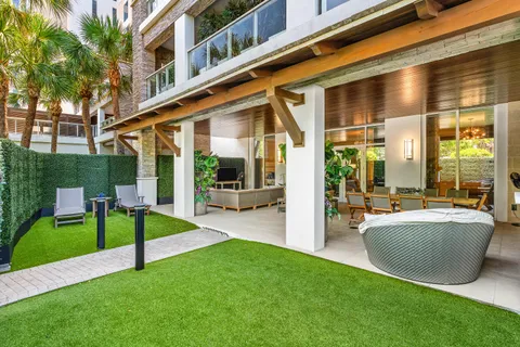 a view of a patio with couches and table and chairs with potted plants
