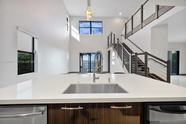 a kitchen with stainless steel appliances granite countertop a sink and a refrigerator