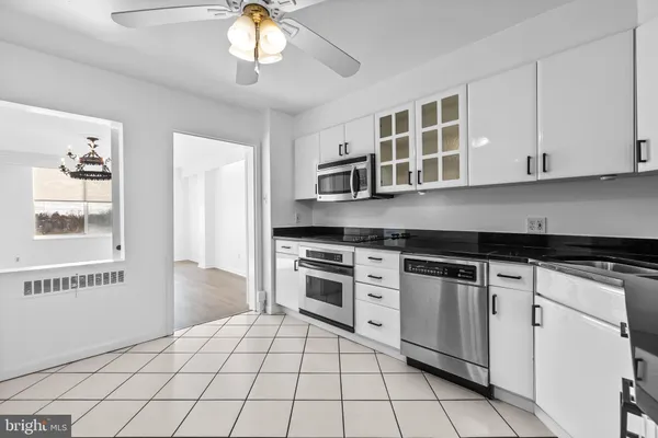 a kitchen with white cabinets a sink and a refrigerator