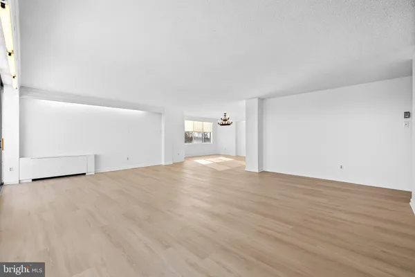 an empty room with cabinet and windows