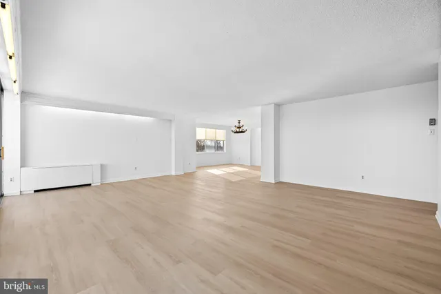 an empty room with cabinet and windows