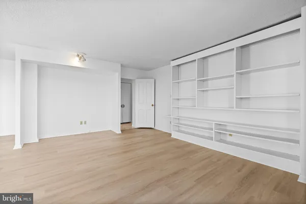 an empty room with windows and a ceiling fan