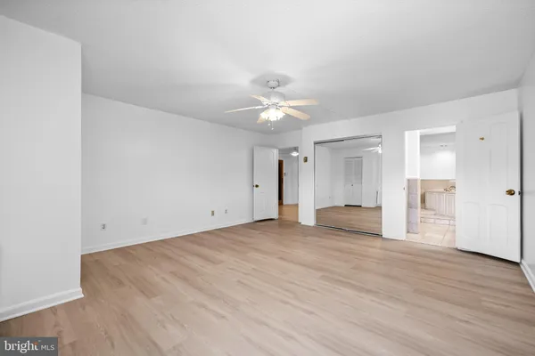 a spacious bathroom with a granite countertop double vanity sink a mirror and a bathtub