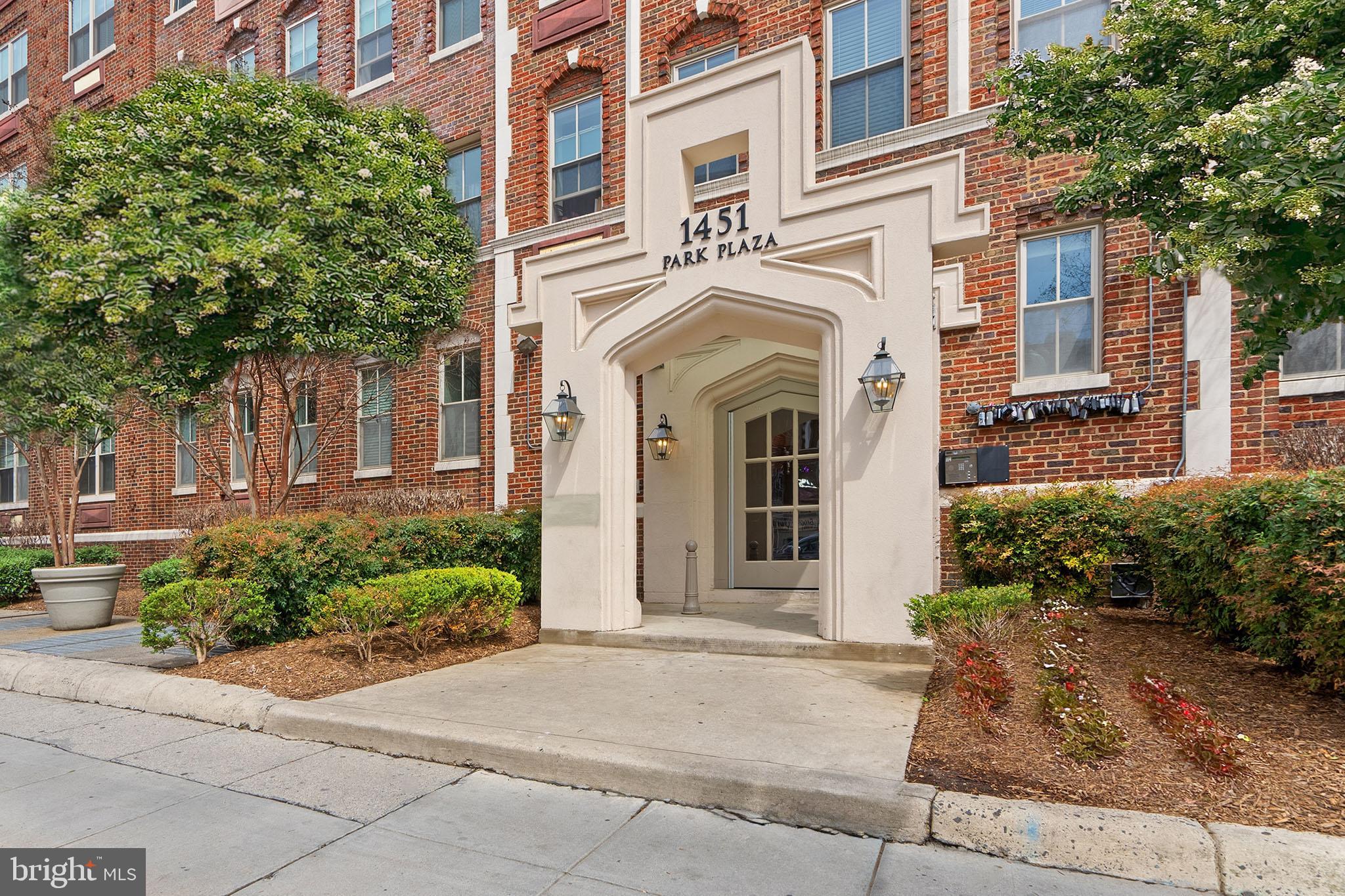 1451 Park Road Northwest, Unit 104 Washington, DC 20010 - Photo 1 of 28 a view of a white house with plants and large tree