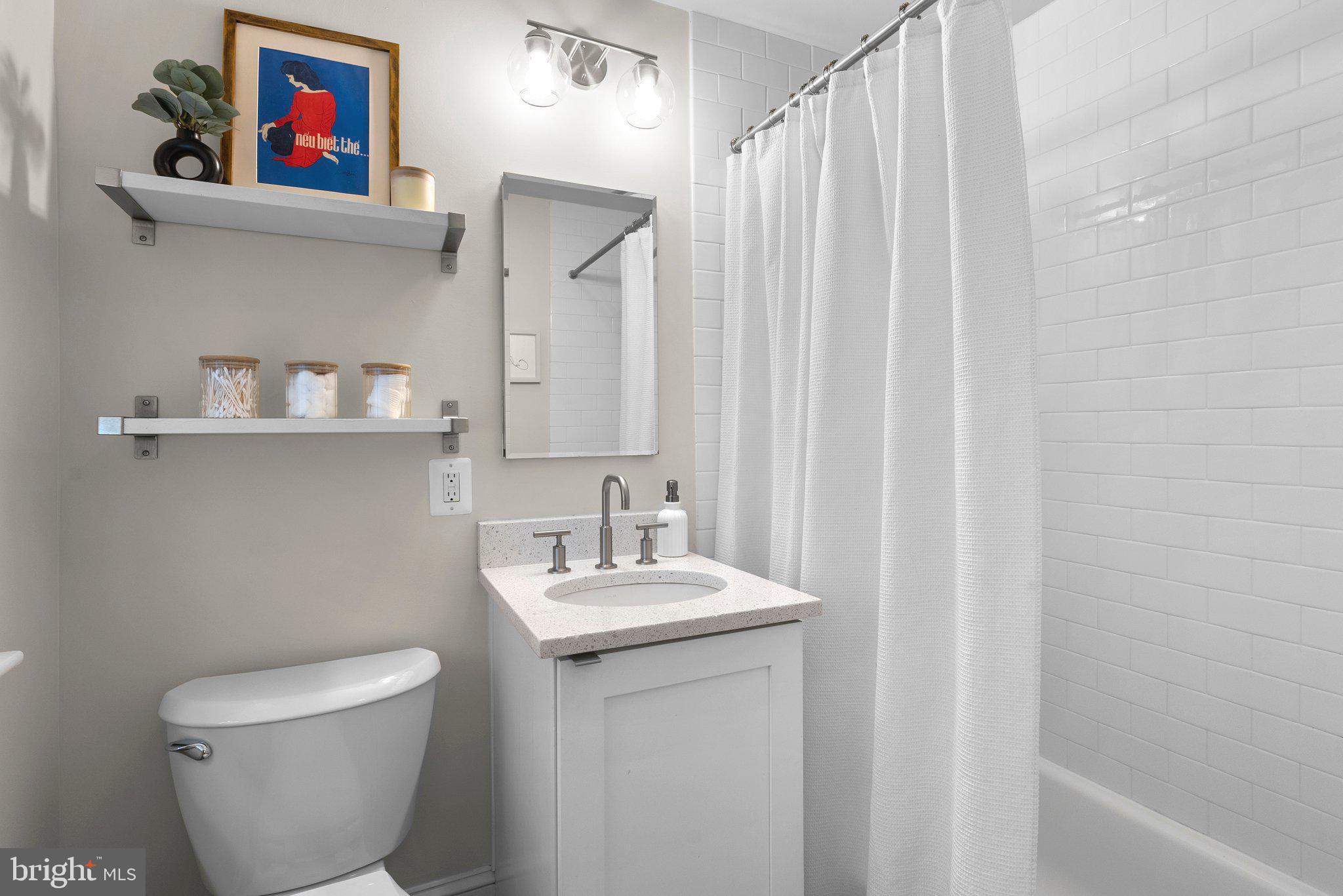 1451 Park Road Northwest, Unit 104 Washington, DC 20010 - Photo 11 of 28 a bathroom with a toilet a sink and a mirror