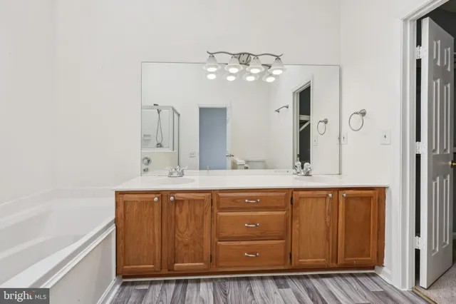 a bathroom with a granite countertop sink a mirror and shower