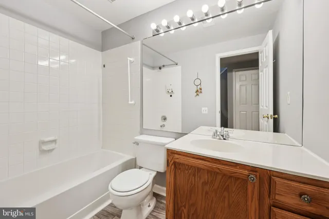 a bathroom with a sink a toilet a mirror and shower