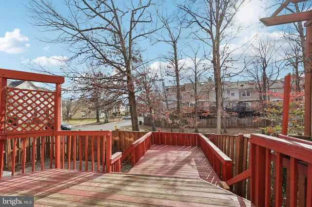 a view of balcony with wooden fence and large trees
