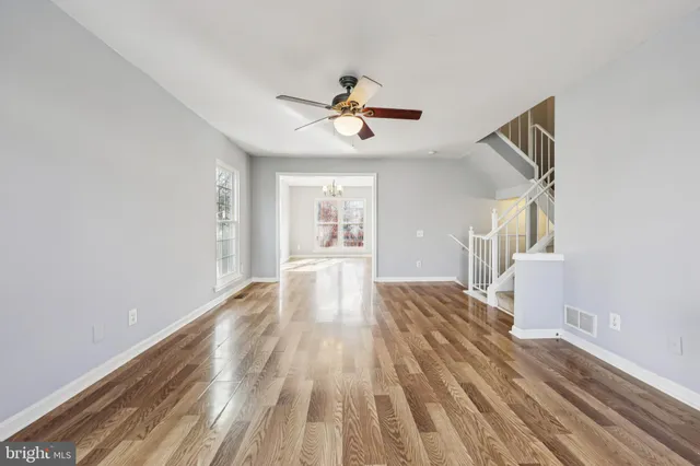 a view of hallway with wooden floor and ceiling fan