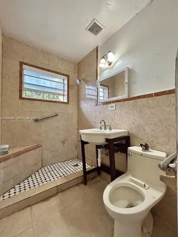 a bathroom with a sink a toilet and a mirror