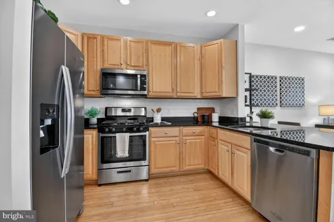 a kitchen with granite countertop a refrigerator stove and microwave