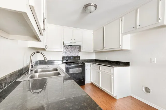 a kitchen with a sink a stove and cabinets
