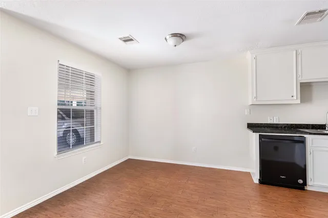 an empty room with windows and fireplace