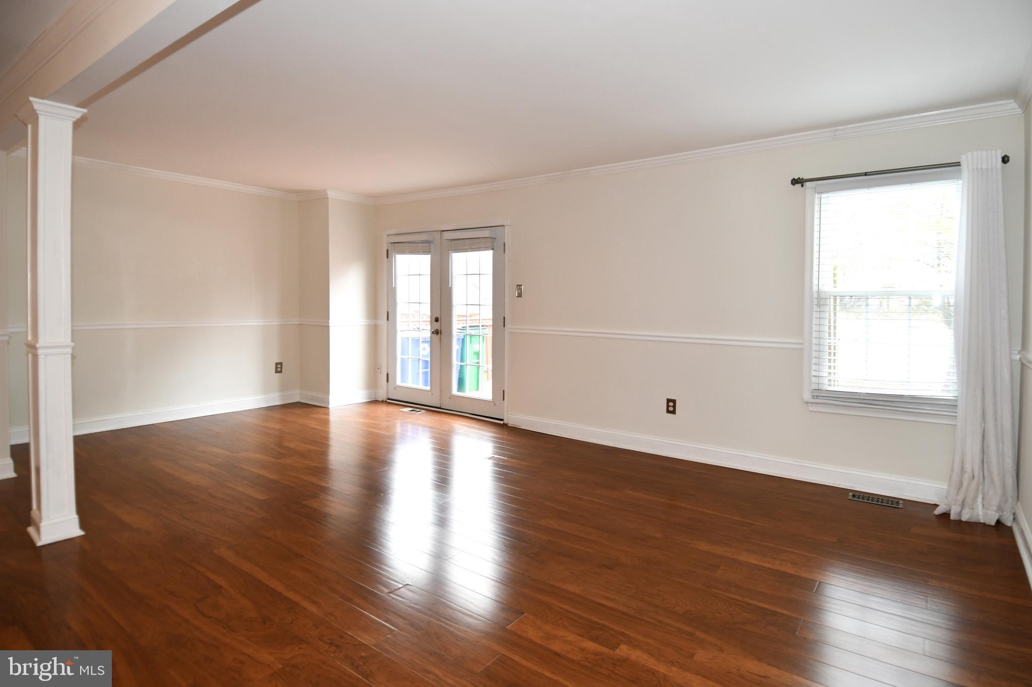 11796 Lone Tree Court Columbia, MD 21044 - Photo 11 of 45 a view of an empty room with wooden floor and a window